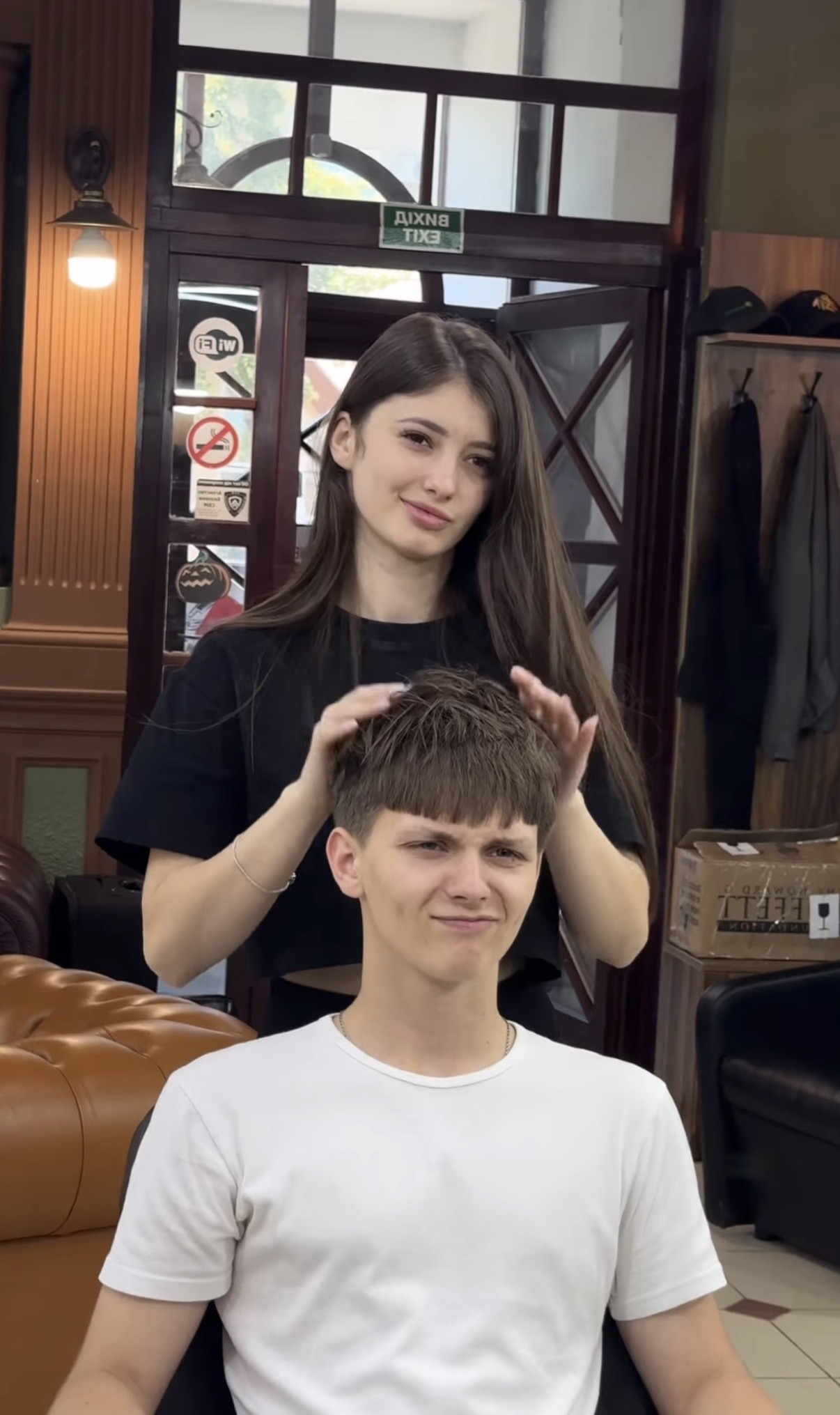 Юлія працює з клієнтом у барбершопі